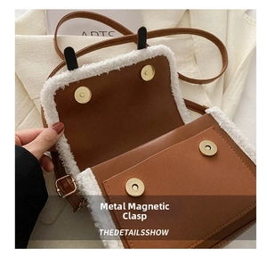 Detail view of the brown crossbody bag showing dual magnetic hardware clasps and fur trim