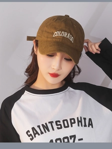 Detail of caramel cotton baseball cap with white Colorado embroidery on a model