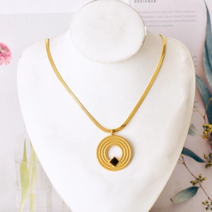 Golden snake chain necklace with circular textured pendant and black square stone detail