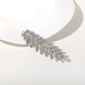 Macro detail of silver metal leaf headband showing intricate vein textures and finish