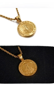 Close-up of golden Virgin Mary miracle medal pendant with twisted rope chain necklace