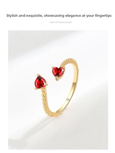 Detail of gold-plated open ring featuring red heart-shaped stones and beaded band