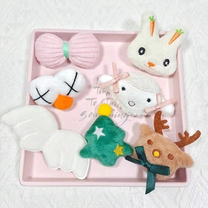 Vue détaillée de breloques en peluche lapin, mouton et cerf sur un plateau rose