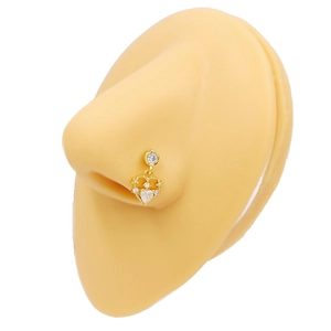 Piercing de nez doré avec pendentif cœur et zircons sur un modèle en silicone