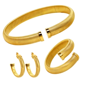Parure de bijoux dorés avec collier torsadé et boucles d'oreilles créoles sur fond blanc