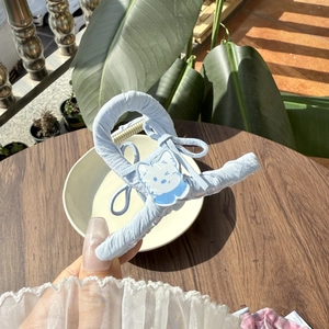 Close-up of a blue fabric wrapped hair claw clip featuring a cute cartoon cat decoration