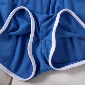 Detailaufnahme der blauen Sporthose mit weißer Paspelierung und Mesh-Stoffstruktur