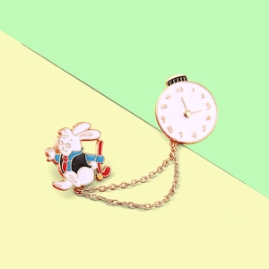 Detail view of rabbit clock enamel pin with golden chains and Alice in Wonderland motif