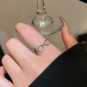 Close-up of creative silver eyewear ring with pink opal stones in a luxury setting