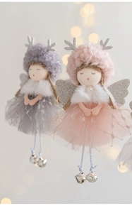 Detail of plush Christmas angel dolls with mesh skirts, antlers and bells on a soft background