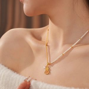 Détail du collier gourde plaqué or 18K avec perles blanches élégantes et cristaux brillants