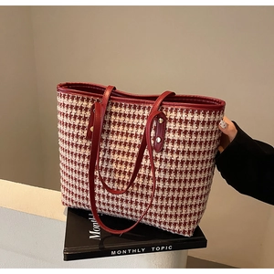 Close-up of red and white houndstooth fabric texture on tote bag with leather straps
