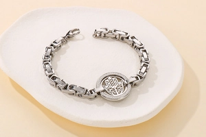 Macro view of stainless steel Hamsa Hand link chain bracelet with micro-pave crystals