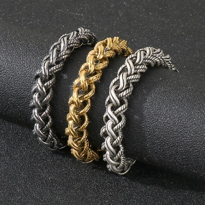 Braided steel rope bracelets in gold, silver and black finishes on a display stand