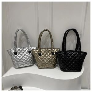 Sacs cabas en tissu matelassé en argent, or et noir sur présentoirs d'exposition