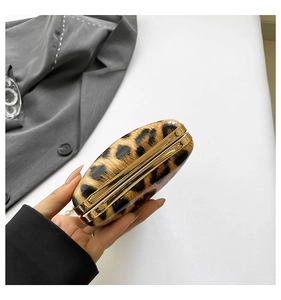 Detail showing the leopard print hard shell evening clutch with gold metal frame and clasp