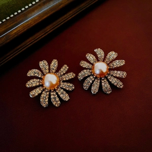 Macro detail of vintage floral earrings with pearls and rhinestones on red leather