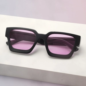 Detail of square black frame sunglasses with trendy translucent purple lenses on stones