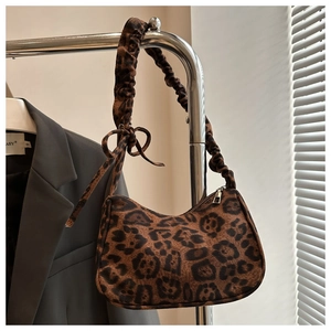 Detail of leopard print handbag featuring ruched shoulder strap and bow decoration
