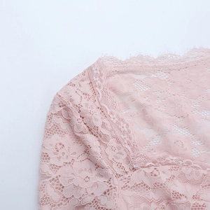 Close-up of pink lace fabric showing intricate floral patterns and eyelash trim