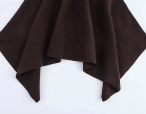Detail of dark brown knitted fabric showing thick wool texture and elegant drape
