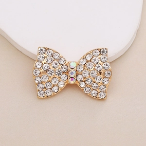 Detailed view of golden bow accessory with sparkling rhinestones and colorful crystals