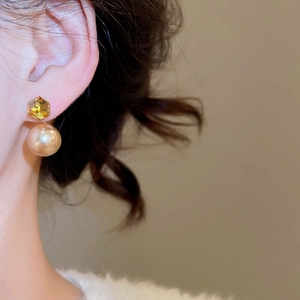 Macro view of 18K gold plated hexagon crystal earring with champagne pearl on model