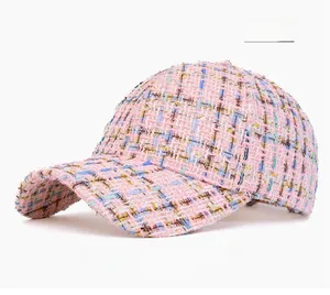 Detail of pink tweed baseball cap featuring textured fabric weave and curved visor