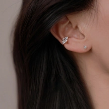 Close-up of silver snake ear cuff with pavé zircons and classic white pearl stud
