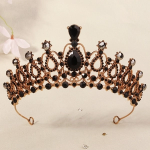 Macro detail of golden crown featuring black gemstones and intricate metal textures