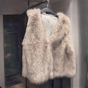 Detail of light beige faux fur vest with soft texture shown on a hanger display