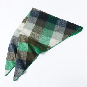 Detail of green plaid cashmere-like scarf showing exquisite stitched edges and fabric texture