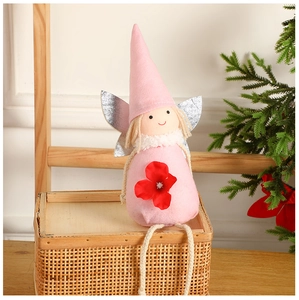 Détail de poupée ange en feutre rose avec ailes argentées sur boîte de rangement tissée