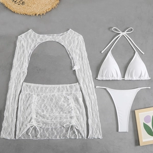Set bikini bianco 4 pezzi con copricostume in pizzo su sfondo grigio effetto cemento