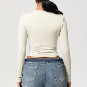 Vue arrière du haut de yoga beige clair à manches longues et coupe ajustée