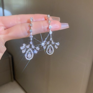 Macro shot of silver drop tassel earrings with sparkling zircon and starburst light effects