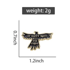 Macro detail of black crow enamel pin with gold engraving It Can't Rain All The Time