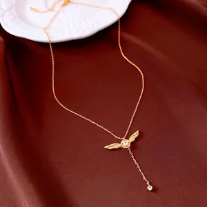 Collier à pendentif ailes dorées avec zircon carré et élégant pompon sur tissu rouge