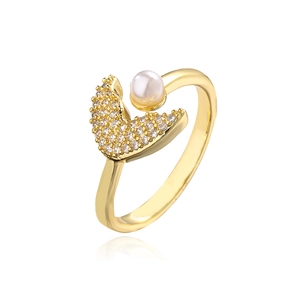Close-up of gold moon ring with pavé zircons and a white pearl on white background