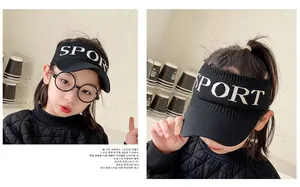 Close-up of black knitted sun visor for kids with white Sport lettering for outdoor activities