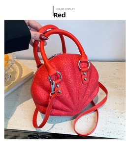 Detail of red shell bag with floral lace texture and adjustable crossbody strap