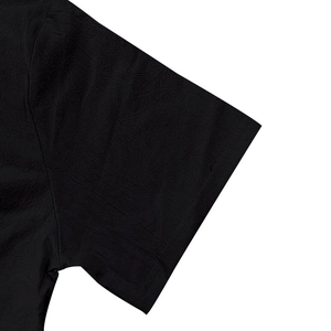 Close-up of black linen texture and buttoned sleeve detail on men's casual shirt