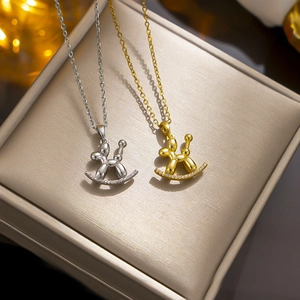 Titanium steel balloon dog necklaces in gold and silver colors on jewelry display