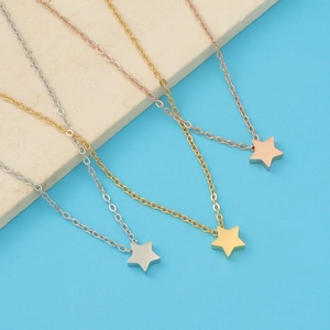 Detailed view of star pendant necklaces in silver, gold, and rose gold stainless steel