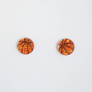 Détail macro des boucles d'oreilles basketball orange pailleté avec lignes noires