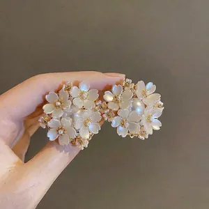 Vue détaillée de boucles d'oreilles fleurs blanches avec perles et strass sur argent