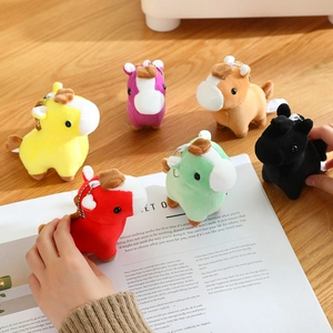 Six colorful plush pony keychains in various colors displayed on a wooden desk