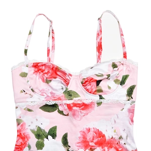 Detail view of pink satin dress with red rose floral prints and white lace trim accents