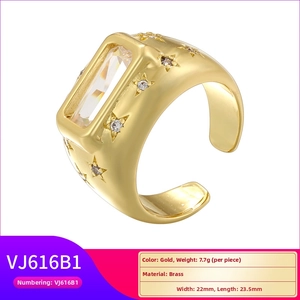 Macro detail of a chunky gold brass ring featuring a large rectangular crystal and star motifs