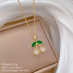 Detailed close-up of cherry pendant necklace with green leaf and white pavé crystals